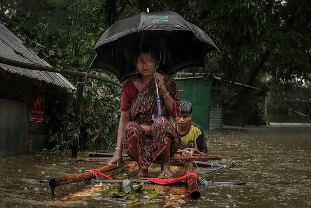 Young boy helping woman during flash flood in Sylhet, Bangladesh